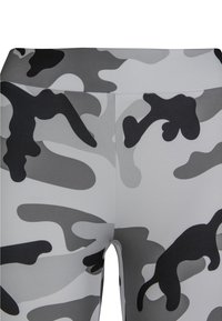 Grå og svart camouflage tights med en glatt tekstur og tettsittende design. Har en høy midje og ingen synlige detaljer.