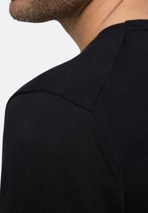 Schwarzer Strickpullover mit enganliegendem Design, das über strukturierte Nähte an Schulter und Kragen verfügt. Glatte Stoffoberfläche, minimalistische Details.