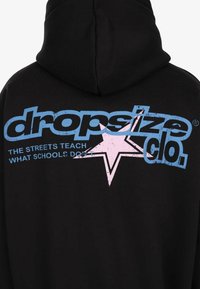 Black hoodie with blue "dropsize clo." text and a pink star, alongside the phrase "THE STREETS TEACH WHAT SCHOOLS DON'T" on the back.