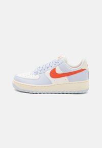 Nike Air Force 1 cipők világoskék és fehér bőrből, narancssárga swoosh-al, texturált felülettel és krémszínű talppal.