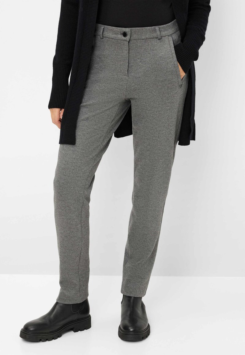 Pantaloni grigi su misura in tessuto testurizzato, caratterizzati da chiusura con bottoni, tasche laterali e vestibilità slim. Indossati con stivaletti neri.