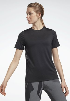 Camiseta atlética negra de manga corta, hecha de una tela suave con un escote redondo clásico, combinada con leggings estampados, que presentan un ajuste ceñido.