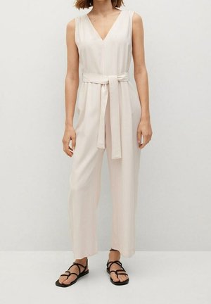Jasnoróżowy kombinezon bez rękawów z dekoltem w kształcie litery V, zebranym w talii, z paskiem wiązanym oraz szerokimi spodniami, wykonany z gładkiego materiału.