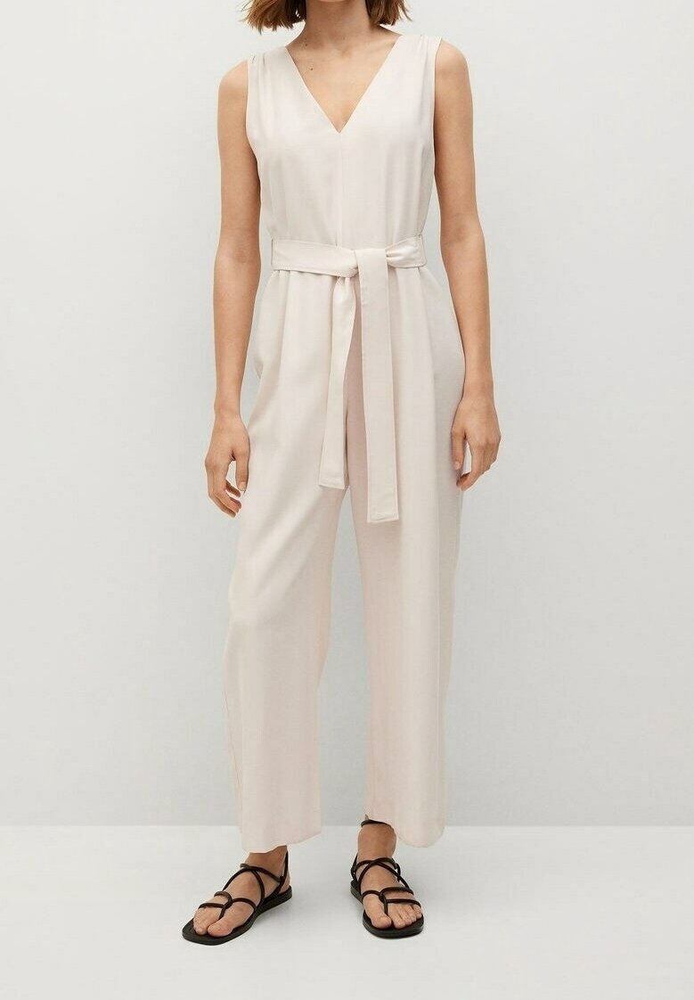 Combinaison sans manches rose pâle avec un décolleté en V, taille cintrée dotée d'une ceinture à nouer et jambes larges, fabriquée en tissu lisse.