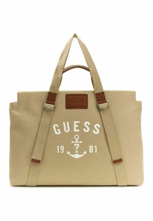 Sac fourre-tout beige Guess avec double poignée, logo ancre à l'avant et "GUESS 1981" imprimé en blanc sur le devant.