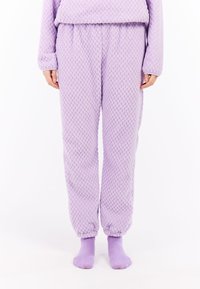 Lavendelkleurige fleece pyjamabroek met textuurstof, taps toelopende boorden en een elastische tailleband; gecombineerd met bijpassende lavendelkleurige sokken.