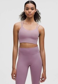 Reggiseno sportivo di un viola chiaro con due spalline sottili, abbinato a leggings a vita alta dello stesso colore, caratterizzati da una texture liscia e cuciture minime.