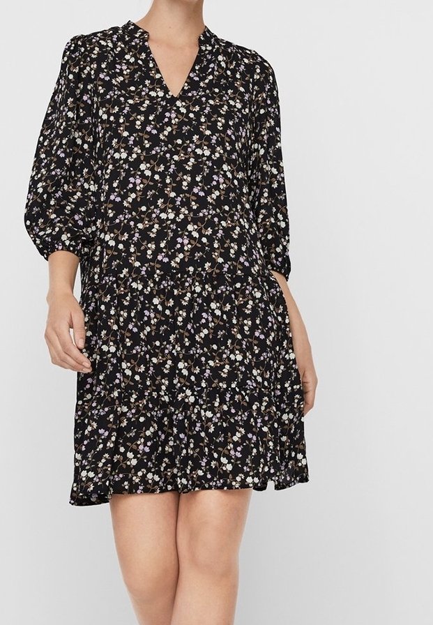 Schwarzes Blumen-Kleid mit V-Ausschnitt, Dreiviertelärmeln und gestuftem Design. Der Stoff hat kleine, bunte Blumenmuster auf der gesamten Fläche.