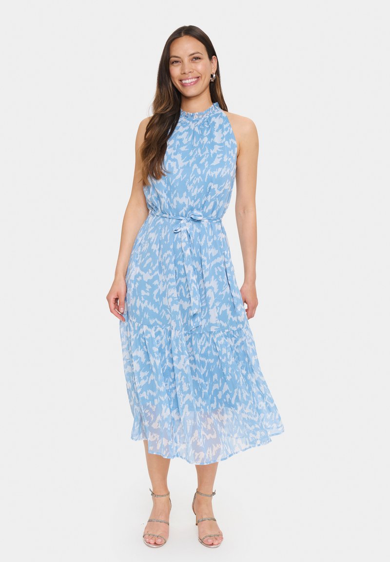 Rochie albastră deschisă cu guler halter, fustă în straturi și un model abstract alb. Prezintă o talie legată și un material semi-transparent.