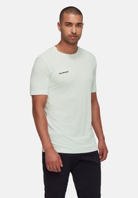 Ljusgrön t-shirt med kort ärm i mjukt material, med rund halsringning och en liten svart "Mammut"-logotyp på vänster bröst.