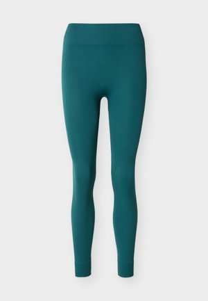 Petroleumsfarvede ribstrikkede leggings med høj talje og tætsiddende ankler, vist på en hvid baggrund.