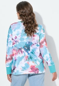 Langärmliger, mehrfarbiger Sweatshirt mit einem Batikmuster in Blau, Pink und Türkis; gerippte türkise Bündchen; entspannte Passform.