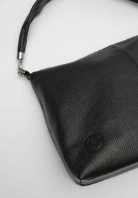 Czarna skórzana torba na ramię o teksturowanym wykończeniu, z pojedynczym paskiem i subtelnym logo wytłoczonym w dolnym rogu.