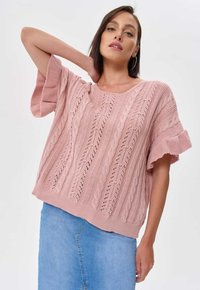Jasnoróżowy sweter z dzianiny, charakteryzujący się wzorem w warkocze, krótkimi rękawami i luźnym krojem. Wyraziste detale ażurowe dodają faktury.