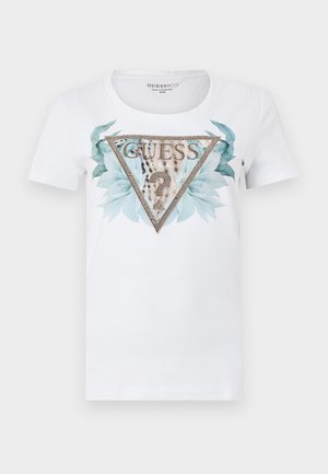 White short-sleeve shirt with a large triangular GUESS logo decorated with small studs, blue-green leaves, and a leopard print question mark inside.