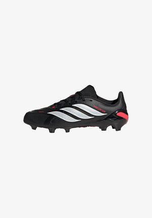 Crna nogometna kopačka s bijelim Adidas prugama, crvenim detaljem na peti i kramponima na potplatu za prianjanje na travnatim površinama.