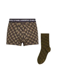 Boxer shorts marrones con patrones abstractos negros y una cinturilla negra. Los calcetines verde olivo presentan un patrón oscuro. Ambos artículos están hechos de una tela suave.