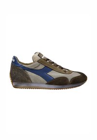 Sneaker con una combinazione di tessuto grigio chiaro e dettagli in suede marrone scuro, dotata di un logo blu e lacci marroni, con una suola in gomma testurizzata.