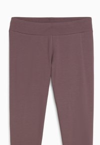 Lila high-waisted Leggings mit einem breiten Bund und glatter Stofftextur, von vorne auf einem weißen Hintergrund gezeigt.