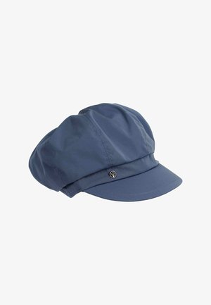 Casquette bleue en tissu doux, avec un sommet rond, une large bande et un petit logo en argent sur le côté. Texture lisse, forme structurée.