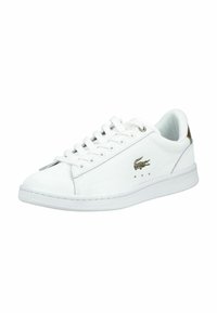 Baskets en cuir blanc avec lacets blancs, logo crocodile vert sur le côté et design à coupe basse.