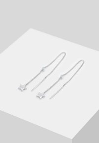 Orecchini a forma di stella in argento con catena e un accento di perla. Presentano un design minimalista con una texture lucida e linee eleganti.