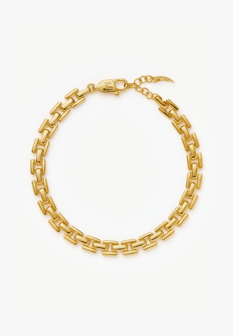 Pulseira de corrente de ouro com elos retangulares alongados e fecho de gancho, repousando sobre um fundo claro.