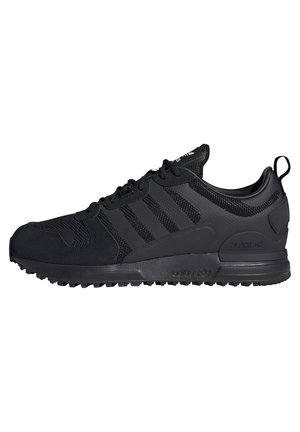 Baskets noires Adidas ZX 700 HD avec détails en mesh et en daim, trois bandes latérales et semelle en caoutchouc texturée sur fond blanc.