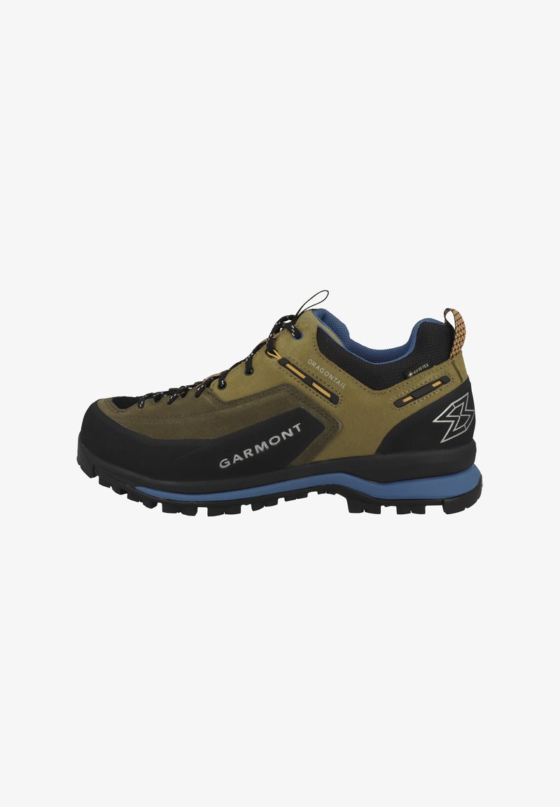 Les chaussures Garmont DragonTail présentent un capuchon en caoutchouc noir, une tige en daim olive, des accents bleus et une semelle extérieure texturée en noir avec des crampons profonds.