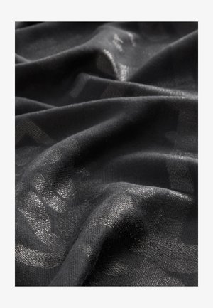 Melnas audums ar mīkstu, teksturētu virsmu; raksturīga smalka spīduma un abstraktu rakstu klātbūtne visā audumā. Gluda, plūstoša izskata.