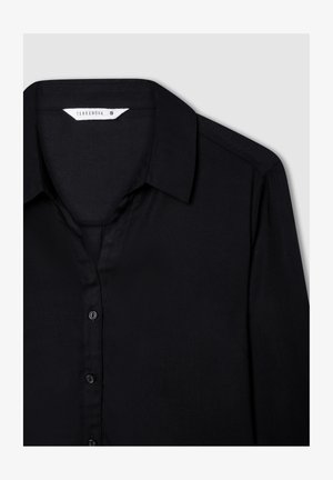 Czarna koszula zapinana na guziki z kołnierzykiem, wykonana z gładkiego materiału, z przodem zdobionym czarnymi guzikami i metką rozmiaru wewnątrz kołnierzyka.
