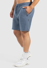 Pantalones cortos de mezcla de algodón azul con cinturilla elástica, cordón y bolsillos laterales, con una textura suave y un ajuste casual.