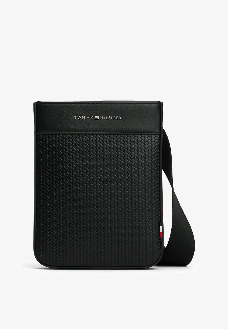 Borsa crossbody nera, texture tessuta sul davanti, parte superiore in pelle liscia, logo in rilievo al centro, tracolla regolabile con accento tricolore.