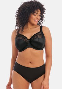 Zwarte bh met satijnen cups en kanten details, met verstelbare bandjes en een strik in het midden. Zwarte high-waisted slipjes maken de look compleet.