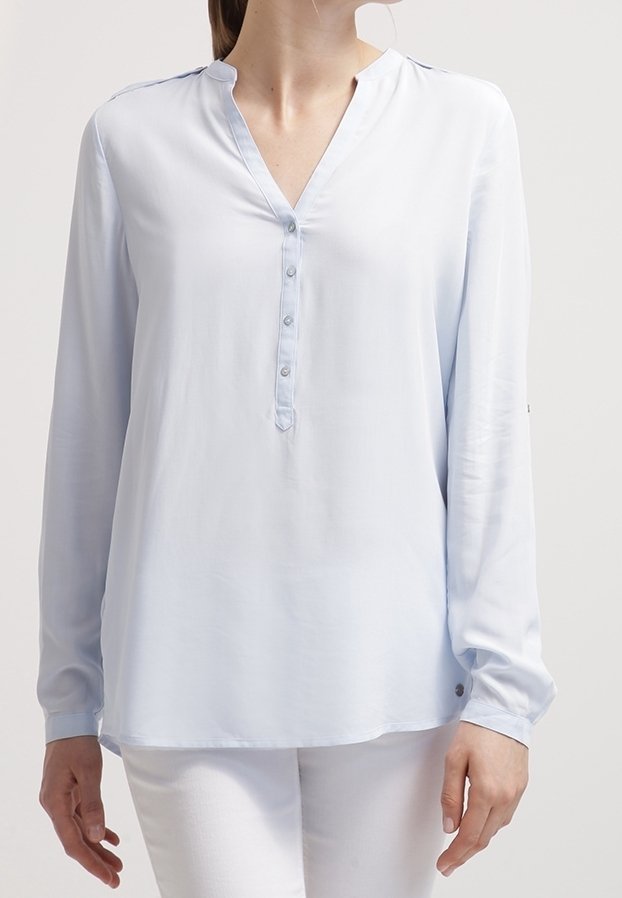 Camicia azzurro chiaro a maniche lunghe con scollatura a V, chiusura a bottoni e maniche con polsini. Tessuto morbido e liscio con una vestibilità comoda.