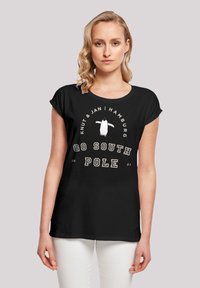 Schwarzes T-Shirt mit aufgerollten Ärmeln, mit einem weißen Pinguin-Graphic und dem Text: "Knut & Jan | Hamburg | GO SOUTH POLE 2023" in hellen Farben.