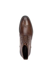 Zapato marrón de cuero con cordones que presenta un diseño brogue, paneles laterales texturizados y una puntera redondeada. Incluye una plantilla con marca.