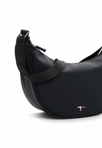 Musta kott, mis on valmistatud siledast materjalist, millel on kõver kuju, peen rihm ja peen läikiv logodekorrastis. Tõmblukk on nähtav.