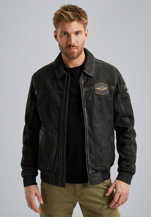 Schwarze Lederjacke mit Reißverschluss, zwei Fronttaschen und gestickten Patches auf der Brust und dem Ärmel. Glatte Textur, taillierte Passform.
