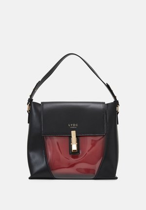 Schwarze Handtasche mit glänzendem dunkelrotem Vorderteil, goldenem Verschluss und einem schwarzen Schulterriemen, mit LYDC London auf der Klappe.
