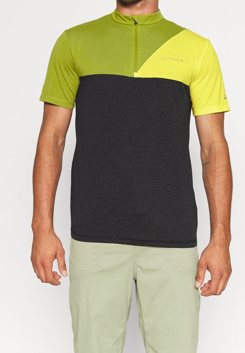 T-shirt de sport à manches courtes avec un bas gris foncé et un haut vert vif, doté d'une fermeture éclair au quart et d'éléments de design contrastants.