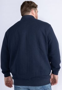 Navy blue sweatshirt with a textured, ribbed surface; features a high collar and elasticized cuffs and hem; back view shown.
