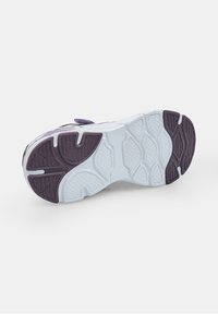 Športová obuv soľ v purpurovej a bielej farbe; textúrovaná guma s jedinečným dezénom; zakrivený tvar; polstrovaná pre pohodlie s bočnými akcentmi.