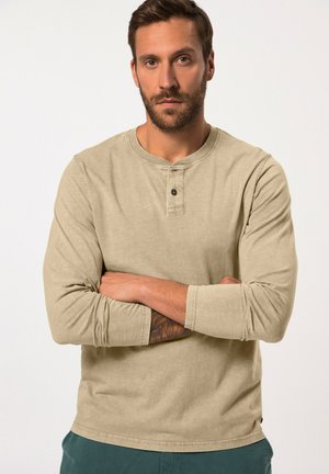 Beige langemouw shirt met een ronde halslijn en een placket met twee knopen. Het heeft een zachte textuur en een licht getailleerd ontwerp.