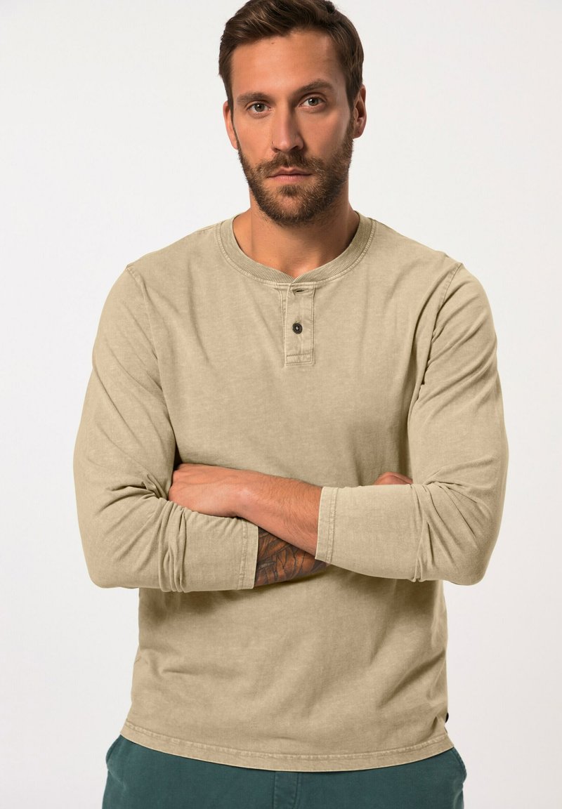 Beige Langarmshirt mit Rundhalsausschnitt und einer zwei-Knopf-Leiste. Es hat eine weiche Textur und eine leicht taillierte Passform.
