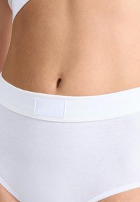 Witte katoen onderbroeken met een zachte tailleband. Label op de voorkant gestikt. Glad materiaal en gegolfde rand langs de beenopeningen.