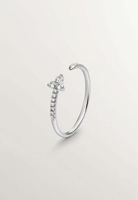 Anillo de plata con un diseño abierto, que presenta un acento de moño decorado con piedras transparentes y una banda suave con un lado texturizado.