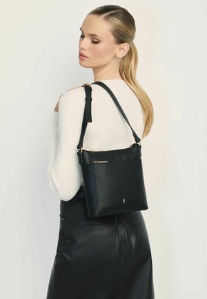 Czarna skórzana torba na ramię z fakturowanym wykończeniem, regulowanym paskiem i złotymi akcentami, wyposażona w zamykaną na zamek kieszeń z przodu.