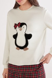 Sudadera blanca con un apliqué de pingüino. El pingüino tiene un cuerpo negro y una textura suave, con un lazo a cuadros rojo y verde en la cabeza.