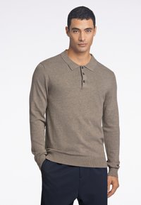 Brązowa polówka z długim rękawem, kołnierzykiem, trzema guzikami oraz ściągaczami na mankietach i dole, wykonana z dzianiny o fakturze.